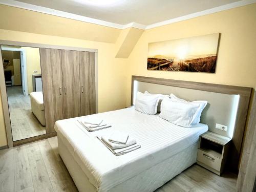 a bedroom with a large bed with white sheets at Private apartments Stamopolu lux in Primorsko