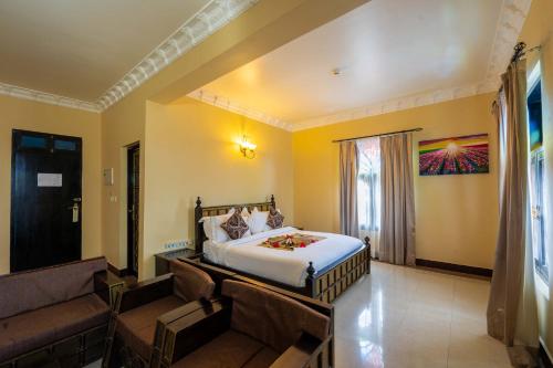 a bedroom with a bed and a couch in a room at Golden Tulip Stone Town Boutique in Zanzibar City