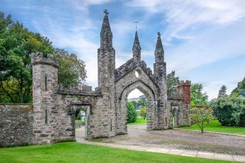 an old stone building with an arch in the grass at The Kenmore Club in Kenmore