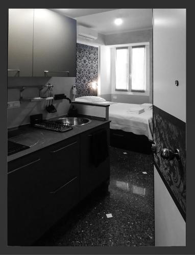 a kitchen with a sink and a bed in a room at Grazioso Monolocale Acquario a 100m free WI-FI in Genova
