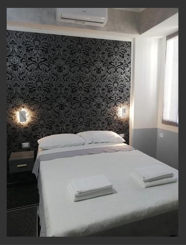 a bedroom with a white bed with a black wall at Grazioso Monolocale Acquario a 100m free WI-FI in Genova