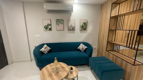 a living room with a blue couch and a table at Saltstayz Premier - Golf Course Extension Road in Gurgaon