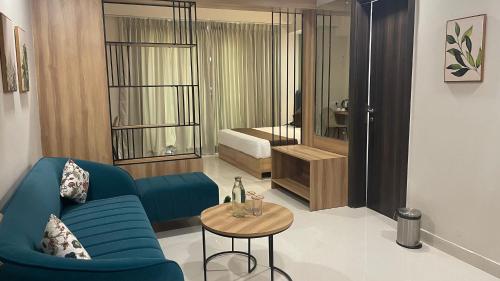 a living room with a blue couch and a table at Saltstayz Premier - Golf Course Extension Road in Gurgaon