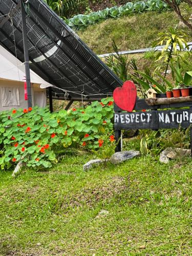 a sign in the grass with a red heart on it at The Backyard Glamping Cameron Highlands in Tanah Rata