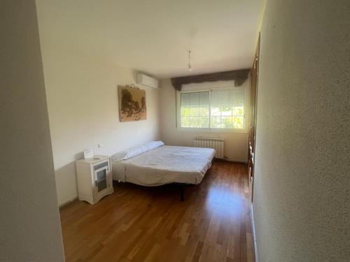 a small bedroom with a bed and a window at Casa grande con gran jardín privado in Quicena