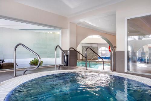 a large swimming pool in a hotel room with a large window at Sahara Sunset in Benalmádena