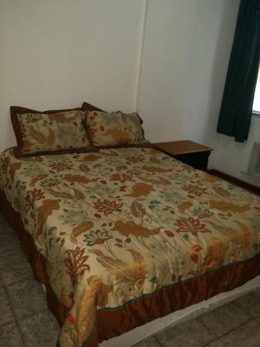 Una cama en un dormitorio con una manta. en Estúdio Djalma Ulrich 91 2, en Río de Janeiro