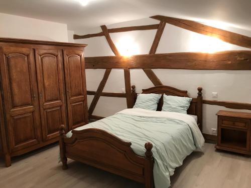Schlafzimmer mit einem Holzbett und einem Holzschrank in der Unterkunft JP Locations in Éclaires