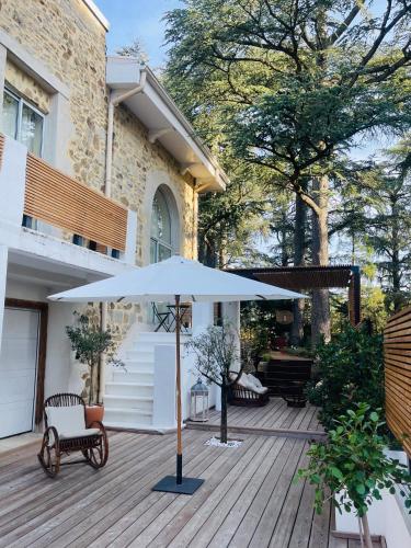 un patio avec un parasol et un banc sur une terrasse dans l'établissement Maison Condorcet, à Saint-Étienne