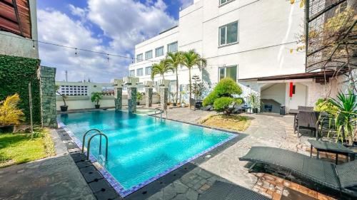 a swimming pool in front of a building at Malyabhara Hotel - formerly Ibis Malioboro in Yogyakarta