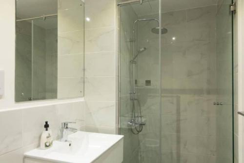 a bathroom with a sink and a shower with a glass door at Blue Sky 2 Bed At Cantonments in Cantonments