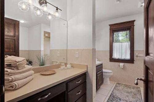 a bathroom with a sink and a toilet and a mirror at Large 6-Bedroom w Pool - Private Chef 
