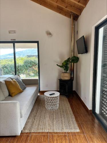 a living room with a couch and a large window at Villa 4 Seasons in São Roque do Pico