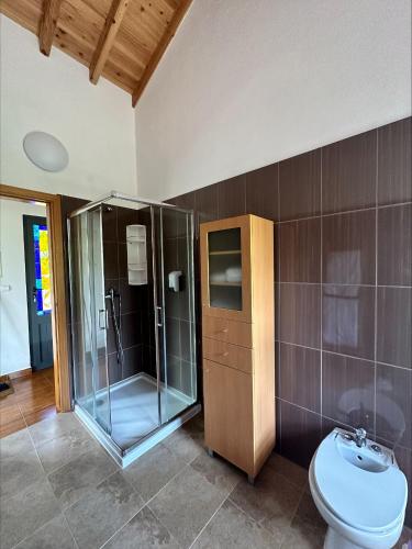 a bathroom with a glass shower and a toilet at Villa 4 Seasons in São Roque do Pico