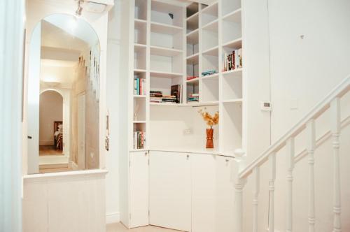 a hallway with white walls and white shelves at Garden flat in period property Centrally located in Bath