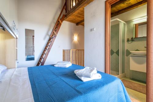 um quarto com uma cama azul com toalhas em Baia delle mimose 2 em Badesi