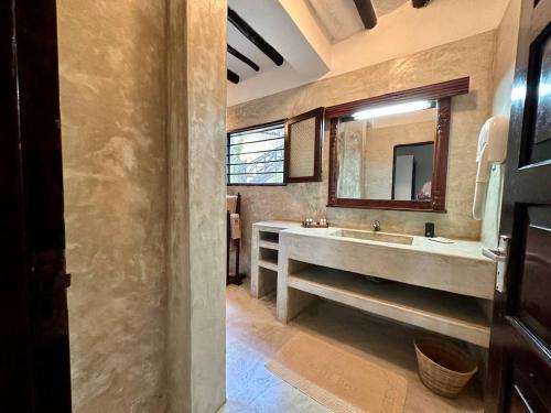 a bathroom with a large sink and a mirror at Blue Bay Village in Watamu