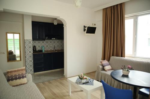 een woonkamer met een tafel en een keuken bij SARAY APART OTEL in Alanya