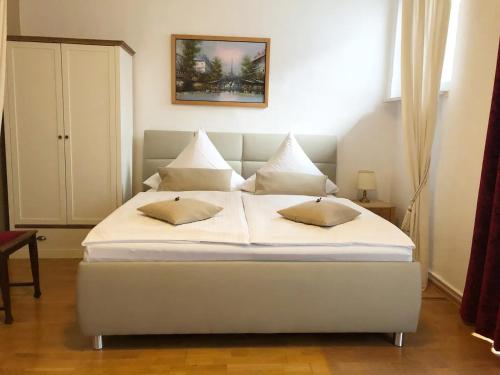 1 cama blanca con almohadas en el dormitorio en Zum Fuchsbau - Schöneiche bei Berlin, en Schöneiche
