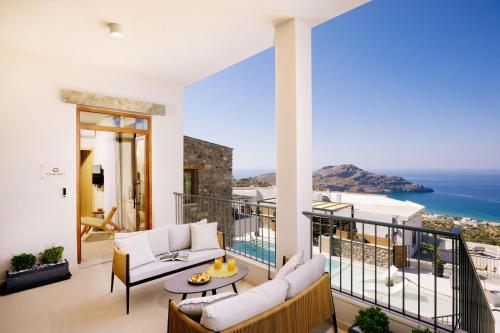 sala de estar con balcón con vistas al océano en Mirthea Suites en Mírthios