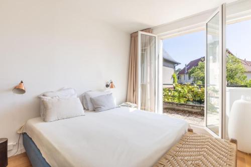 a bedroom with a white bed and a large window at Superbe Maison 8 pers proche de Paris in Boulogne-Billancourt