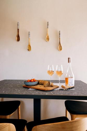 a table with two glasses of wine and two wine bottles at Mirthea Suites in Mírthios