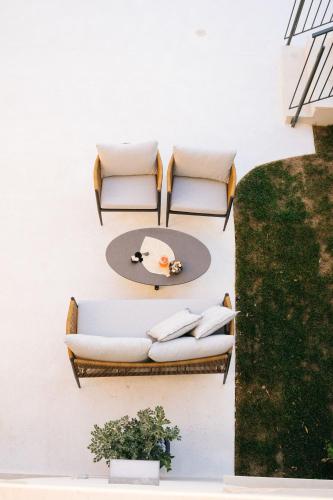 two chairs and a table on a wall at Mirthea Suites in Mírthios