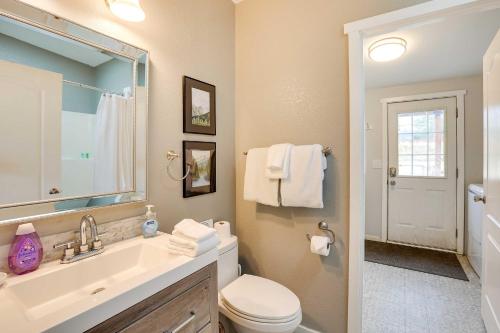 a bathroom with a sink and a toilet and a mirror at Serene Sequim Retreat with Deck Pets Welcome! in Sequim