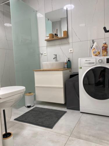 ein Badezimmer mit einer Waschmaschine und einem Waschbecken in der Unterkunft Business Suite 04 mit Netflix Premium & Parkplatz, zentral zu Audi & Schwarz Gruppe with Fußbodenheizung in Bad Friedrichshall