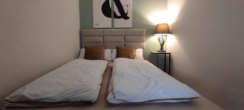 a bed with two pillows and a lamp in a room at Wohlfühloase im Herzen von Wiedenbrück in Rheda-Wiedenbrück
