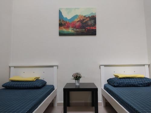 2 camas en una habitación con una foto en la pared en 4 airconditioned rooms and fully furnished Guesthouse in Muar Town en Muar