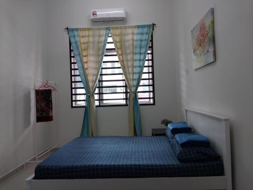 een slaapkamer met een bed voor een raam bij 4 airconditioned rooms and fully furnished Guesthouse in Muar Town in Muar