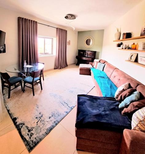 ein Wohnzimmer mit einem Sofa und einem Tisch in der Unterkunft Bird of Paradise in Mosta