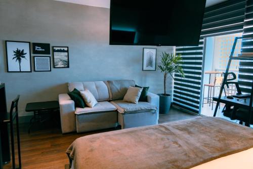 a living room with a couch and a chair at Studio a 100m Bosque, Centro e Cambuí- Home Office, Piscina, Sauna, Jacuzzi, Fitness in Campinas