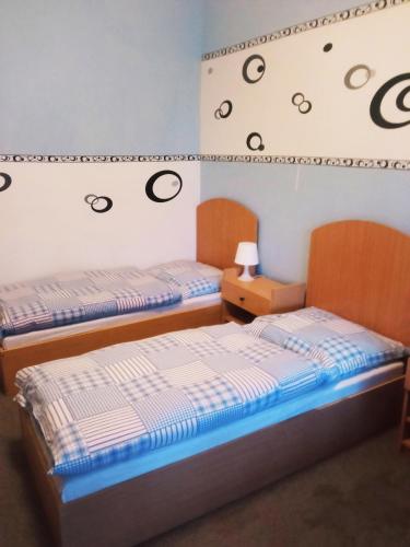 two beds in a room with a wall with drawings on it at Hostinec u Kačaby in Jihlava