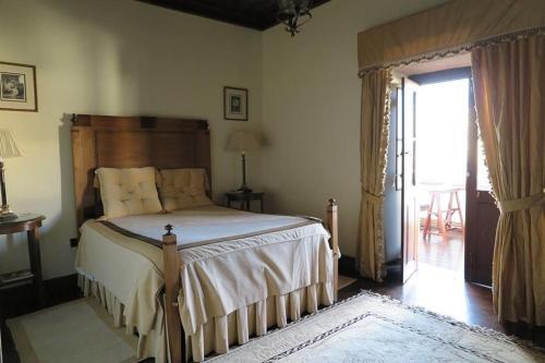 a bedroom with a large bed and a sliding glass door at Solar de Santa Maria in Bragança