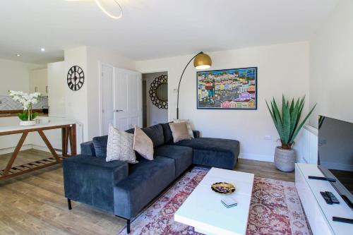 a living room with a blue couch and a table at Fairfields View in Milton Keynes