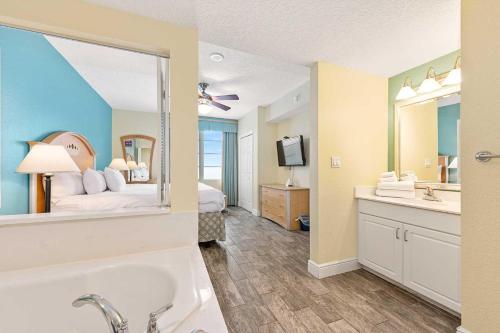 1 dormitorio con 1 cama y baño con bañera. en Luxury 3BR Villa Wyndham Ocean Walk Resort en Daytona Beach