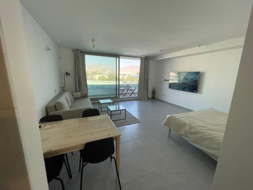 a room with a bed and a couch and a table at oR-Ya Suite in Eilat