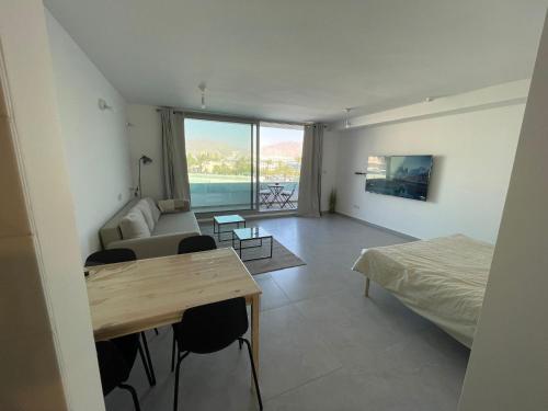 Cette chambre comprend un lit, un canapé et une table. dans l'établissement oR-Ya Suite, à Eilat