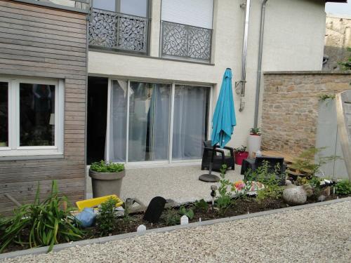 a garden in front of a house with an umbrella at Le patio d'antan, le cosy in Florémont