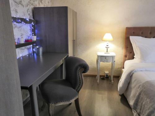 a bedroom with a desk and a bed and a chair at Le patio d'antan, le cosy in Florémont