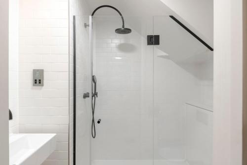 a shower with a glass door next to a sink at The Socialite - Covent Garden - by Frankie Says in London