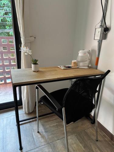 a wooden table with a black chair under it at CoLinkHouse Hotel in Medellín