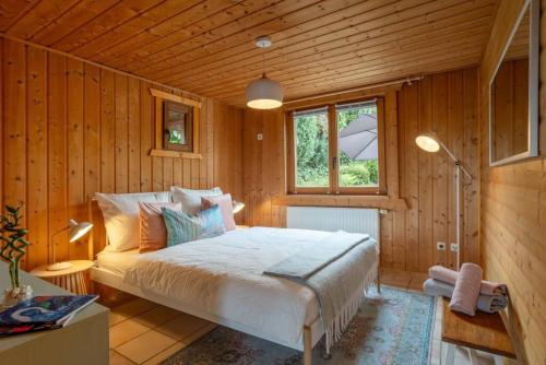 a bedroom with a bed in a wooden room at Panoramic Chalet Hot Tub, BBQ, view, terrace in Gönnersdorf