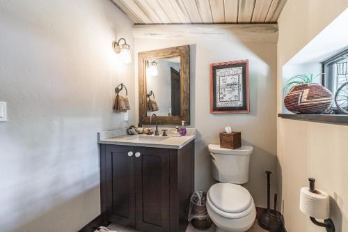 a bathroom with a toilet and a sink and a mirror at Slippery Rock River Ranch in Dolores