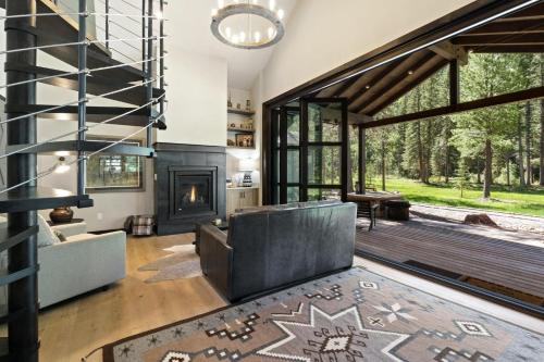 a living room with a fireplace and a staircase at Slippery Rock River Ranch in Dolores