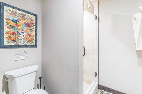 a bathroom with a toilet and a painting on the wall at Slippery Rock River Ranch in Dolores
