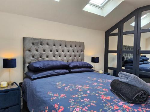 a bedroom with a large bed with blue sheets and blue pillows at 5 Star Luxury Small Cosy House with Lake View in Doncaster