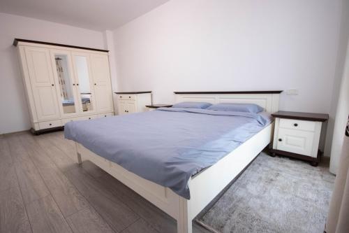 a bedroom with a large bed and two night stands at DownTown Apartments in Rădăuţi